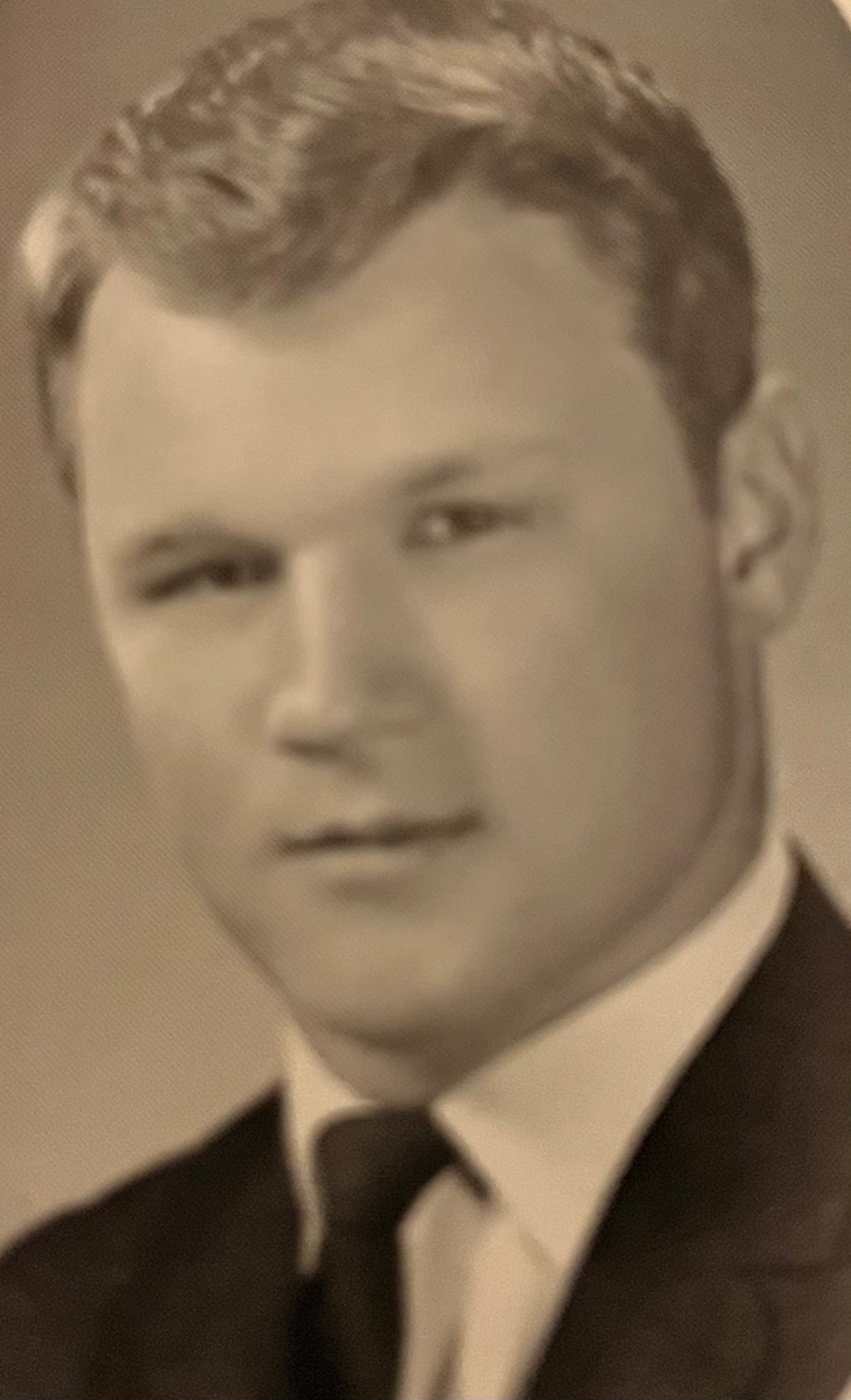 A black and white photo of a man in a suit and tie.