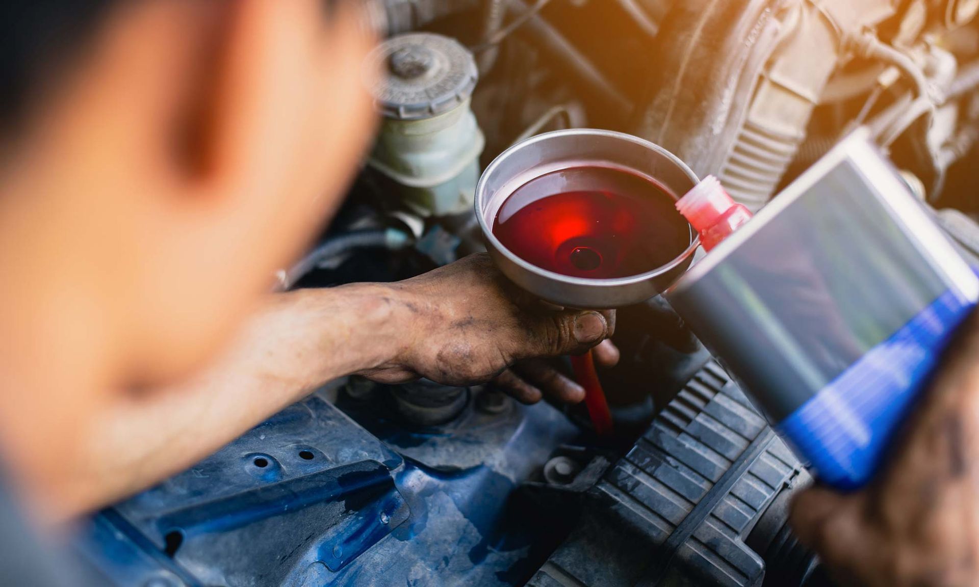 Transmission fluid being poured into vehicle