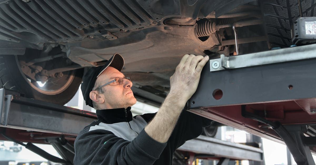A man is working under a car in a garage. | Jeff's Auto Repair