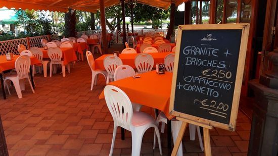 Un ristorante con tavoli e sedie e un cartello che dice granite e brioches