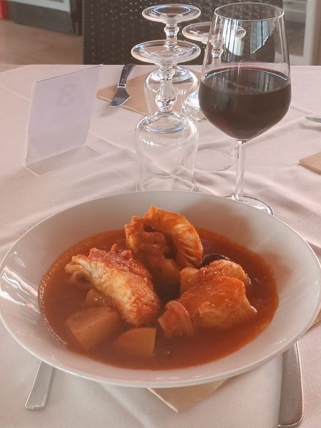 Una ciotola di zuppa e un bicchiere di vino su un tavolo