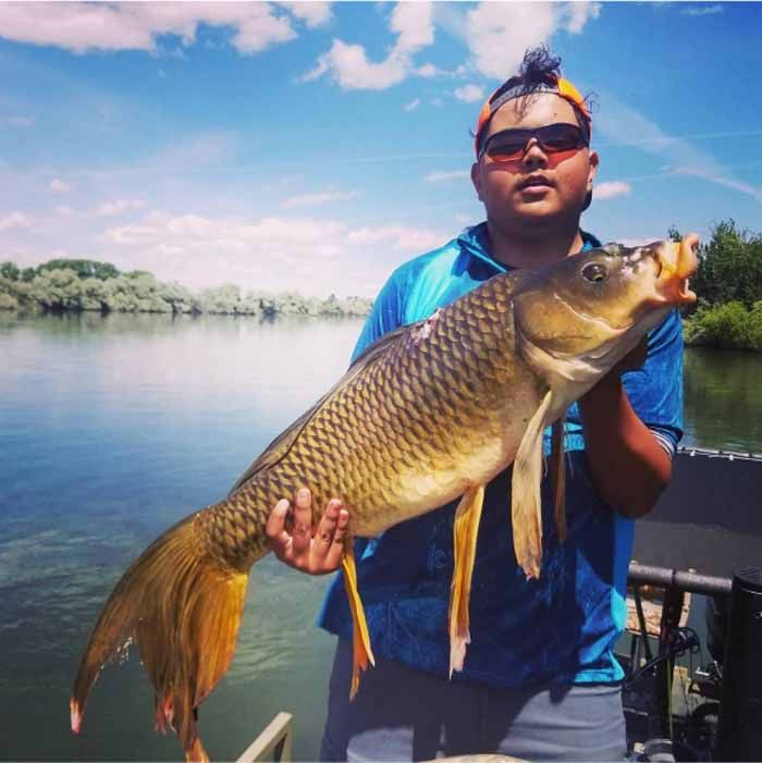 A man is holding a large fish in his hands