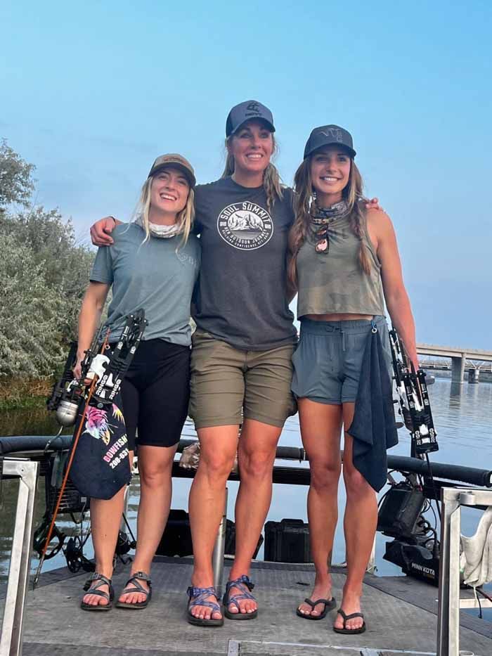 Three women are posing for a picture on a boat.