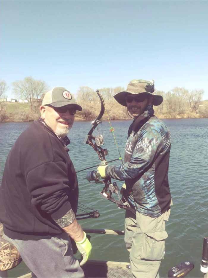 Two men are fishing on a boat in the water