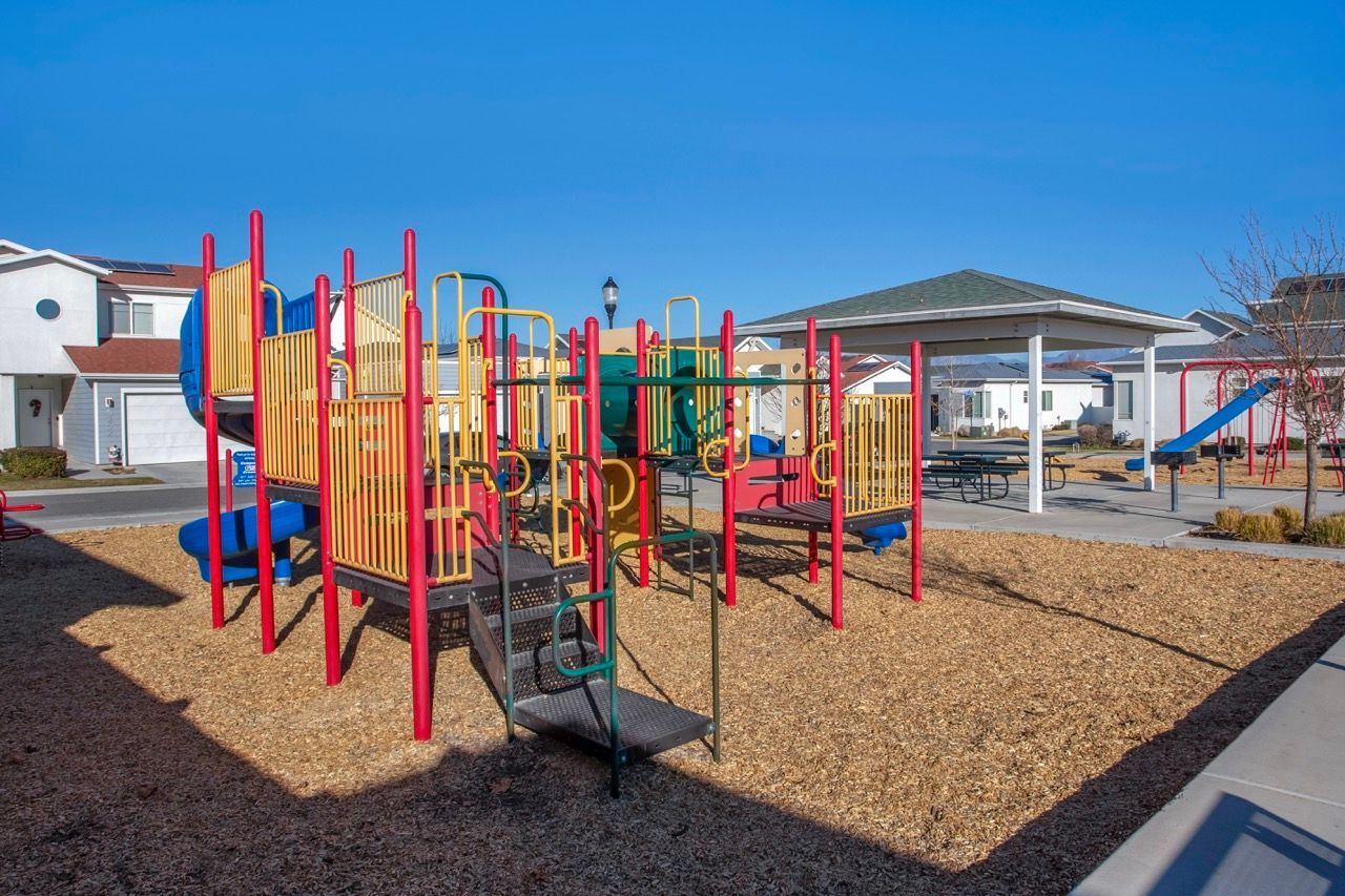 Colorful playground with slides and climbing structures at a residential community.