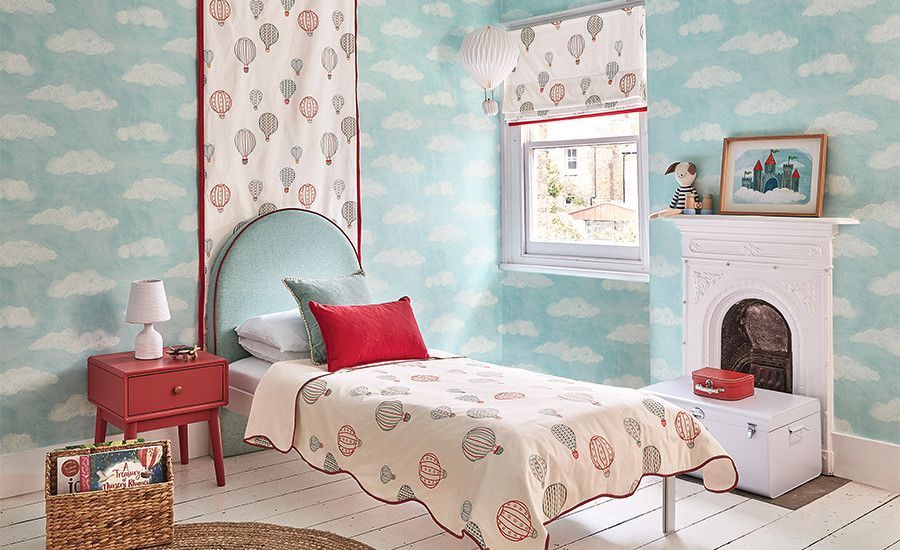 Pastel bedroom with teal walls, red bedside table, white bed, window, and fireplace mantel