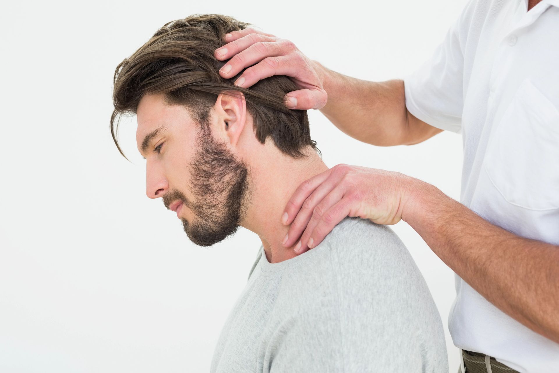 Man receiving neck massage from another person.