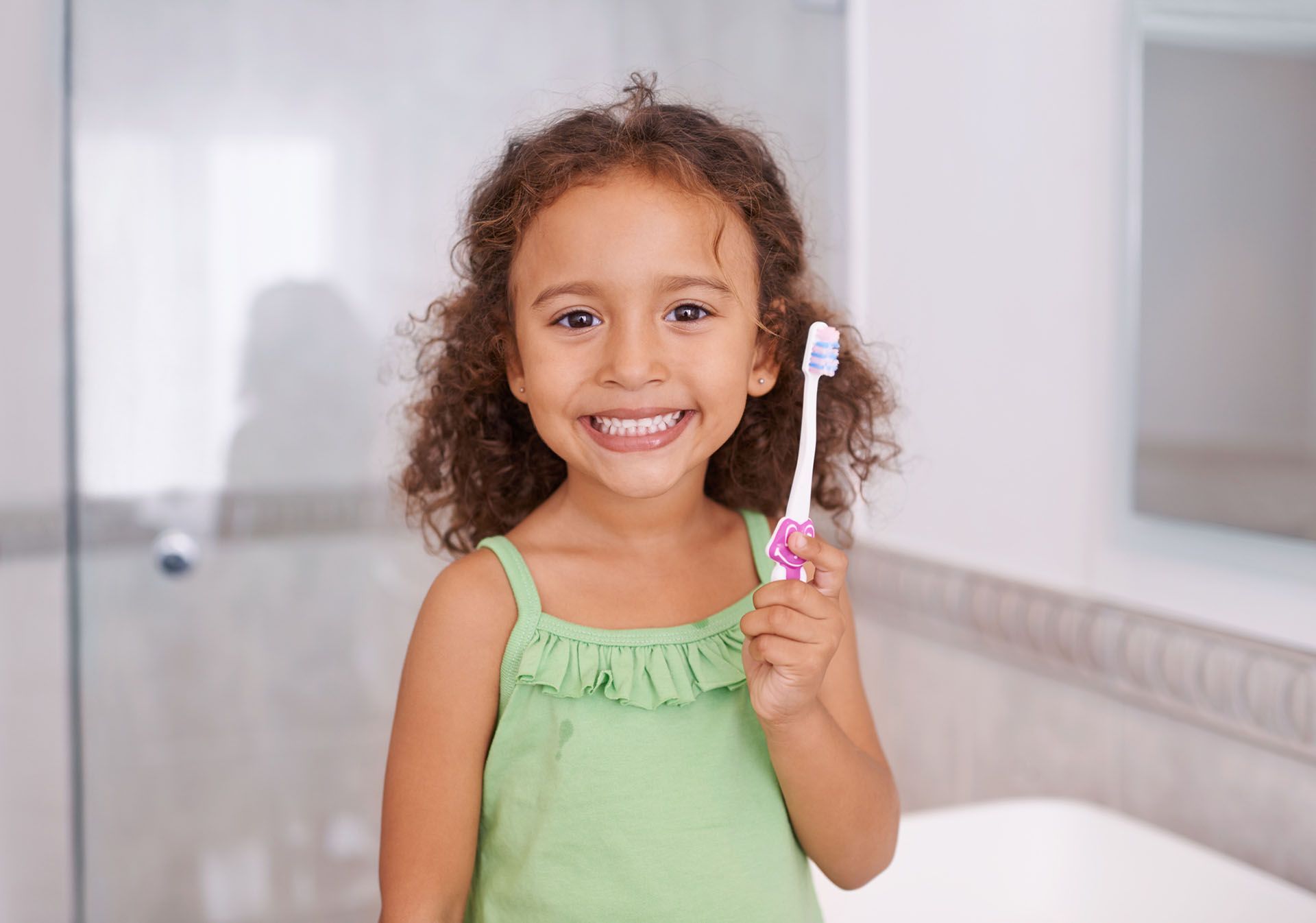 Girl Holding a Toothbrush — Mandeville, LA — Northshore Pediatric Dentistry