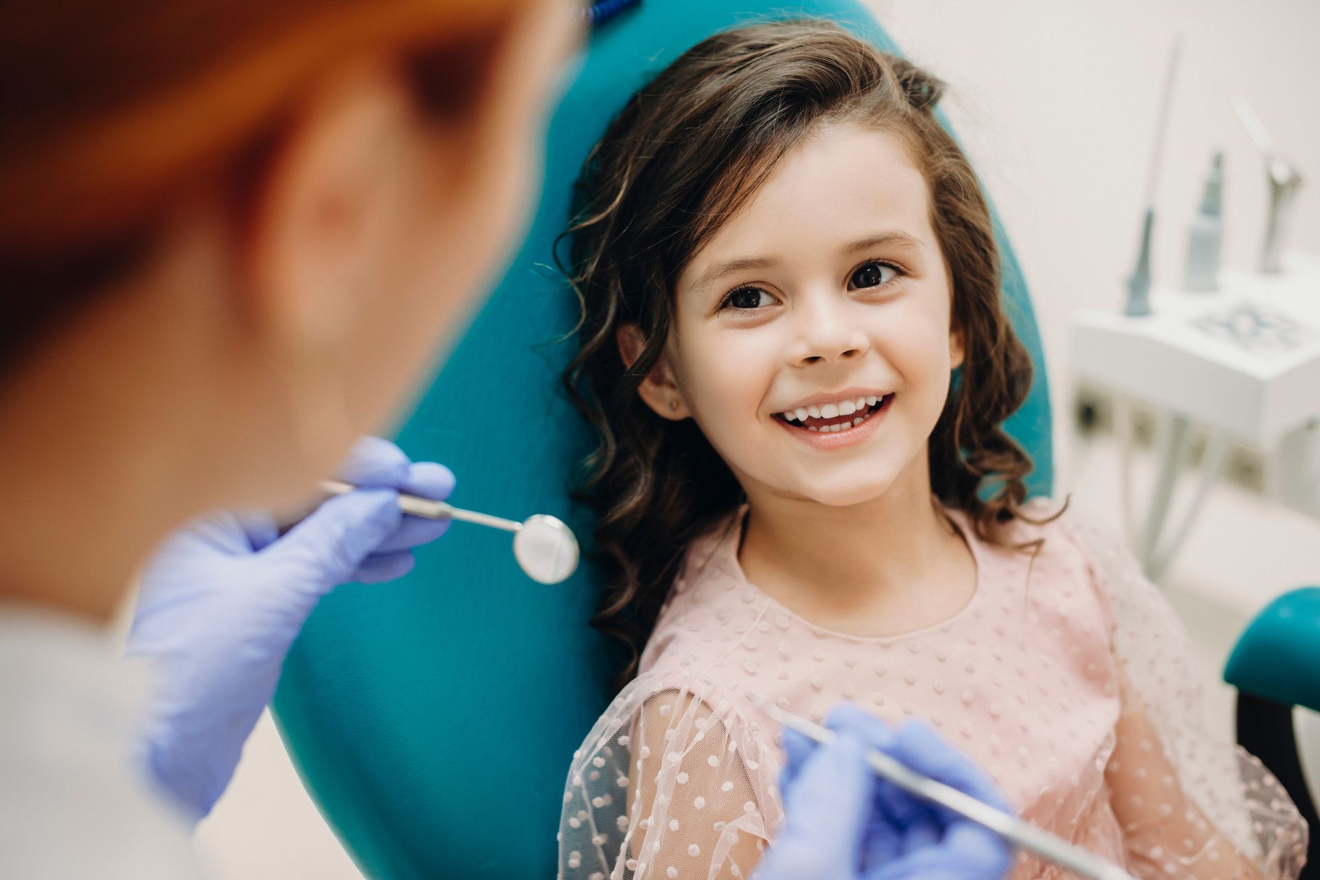 Lovely little kid smiling while talking with the pediatric dentist. Lovely little kid smiling while talking with the pediatric dentist.