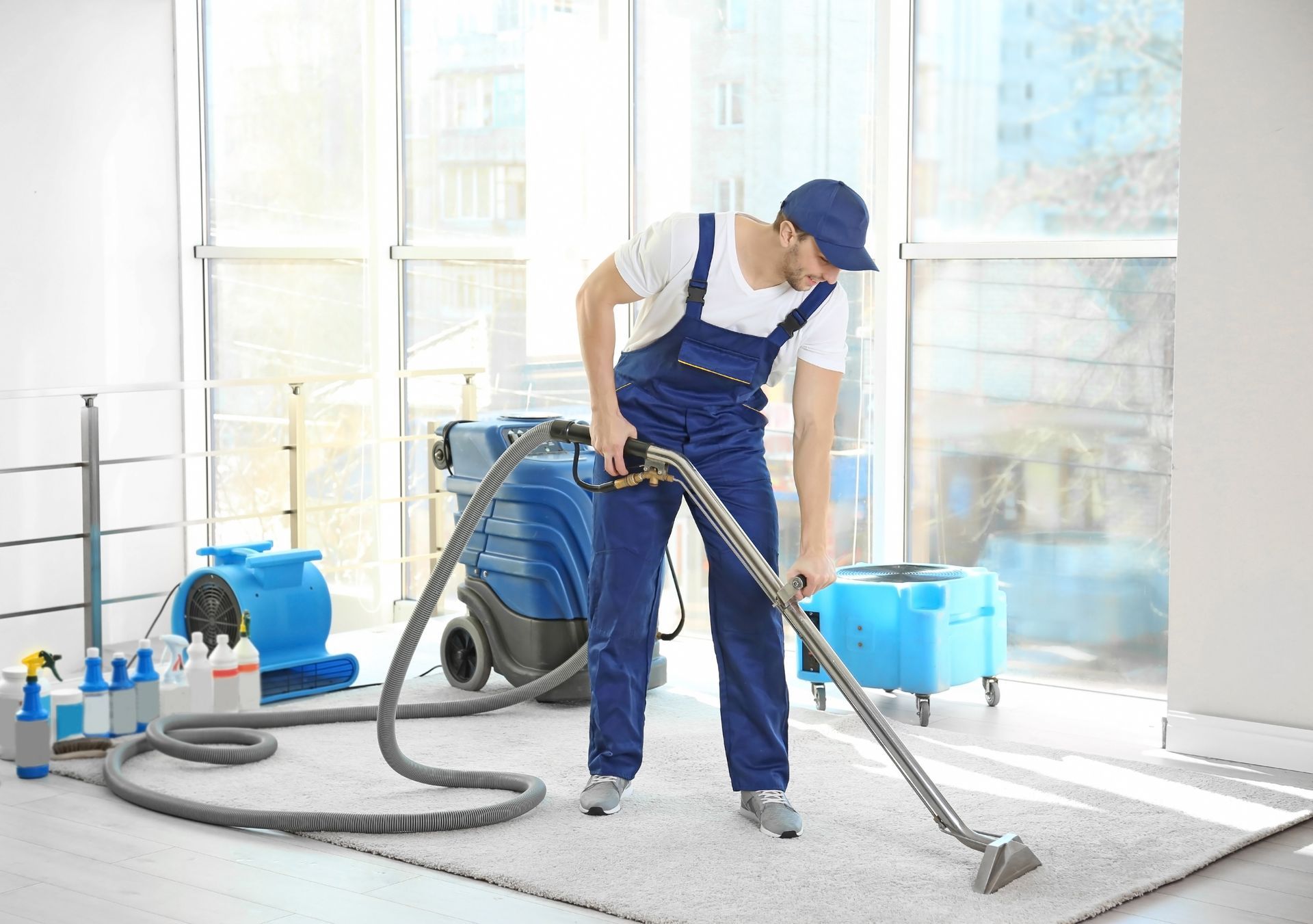 Dry cleaner's employee removing dirt from carpet in flat.