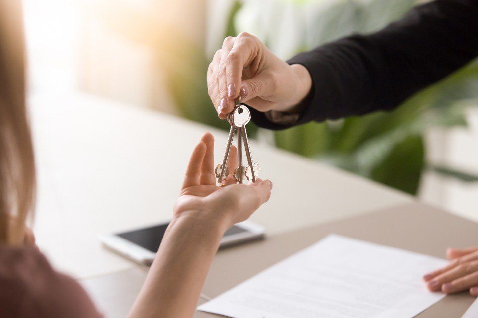 Agente immobiliare consegna chiavi di casa a cliente