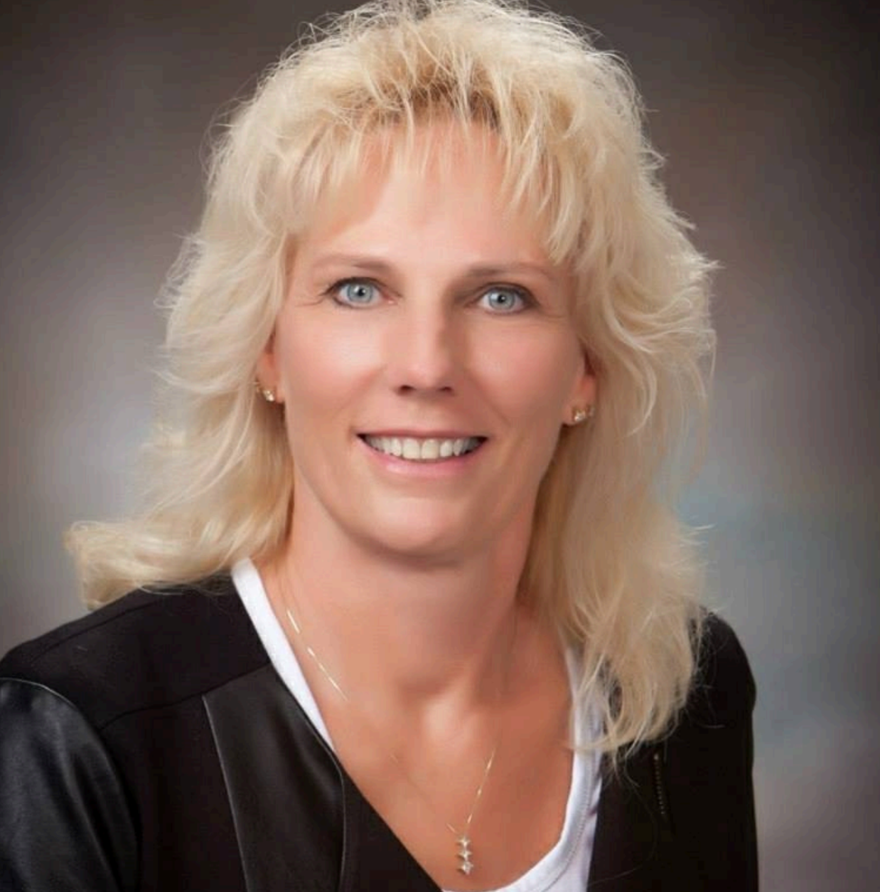 A woman with long black hair is smiling in a circle.