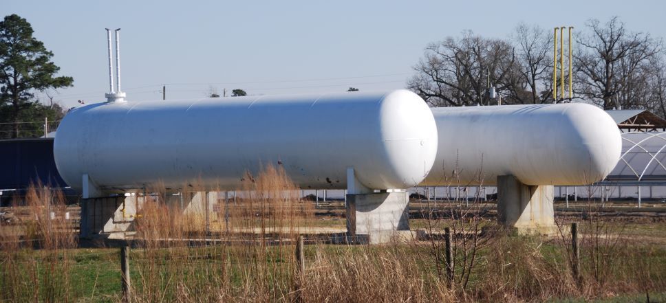 View through glass door of a 76 gas station with pump and signage outside.
