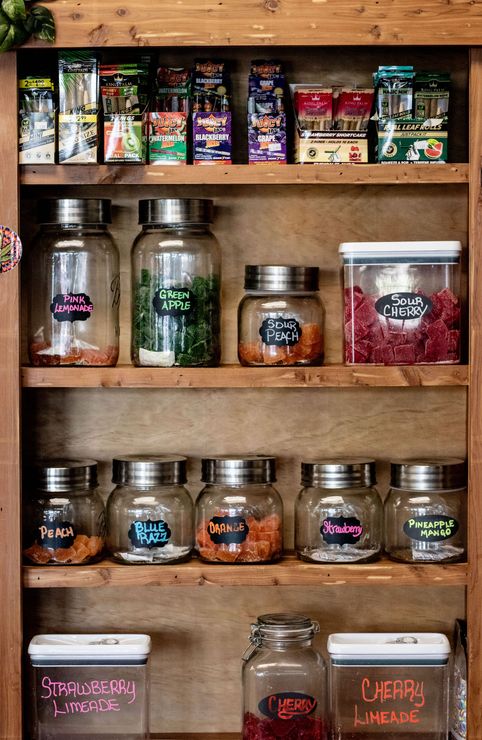 A wooden pantry filled with jars and containers of food.