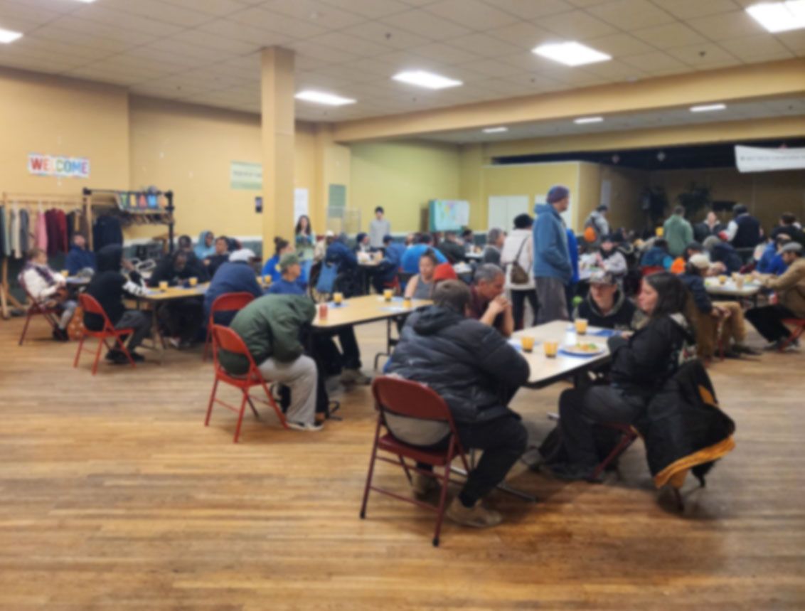 A group of people are sitting at tables in a large room