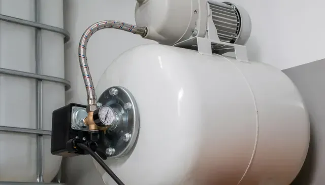 White water pressure tank with attached motor and pressure gauge.