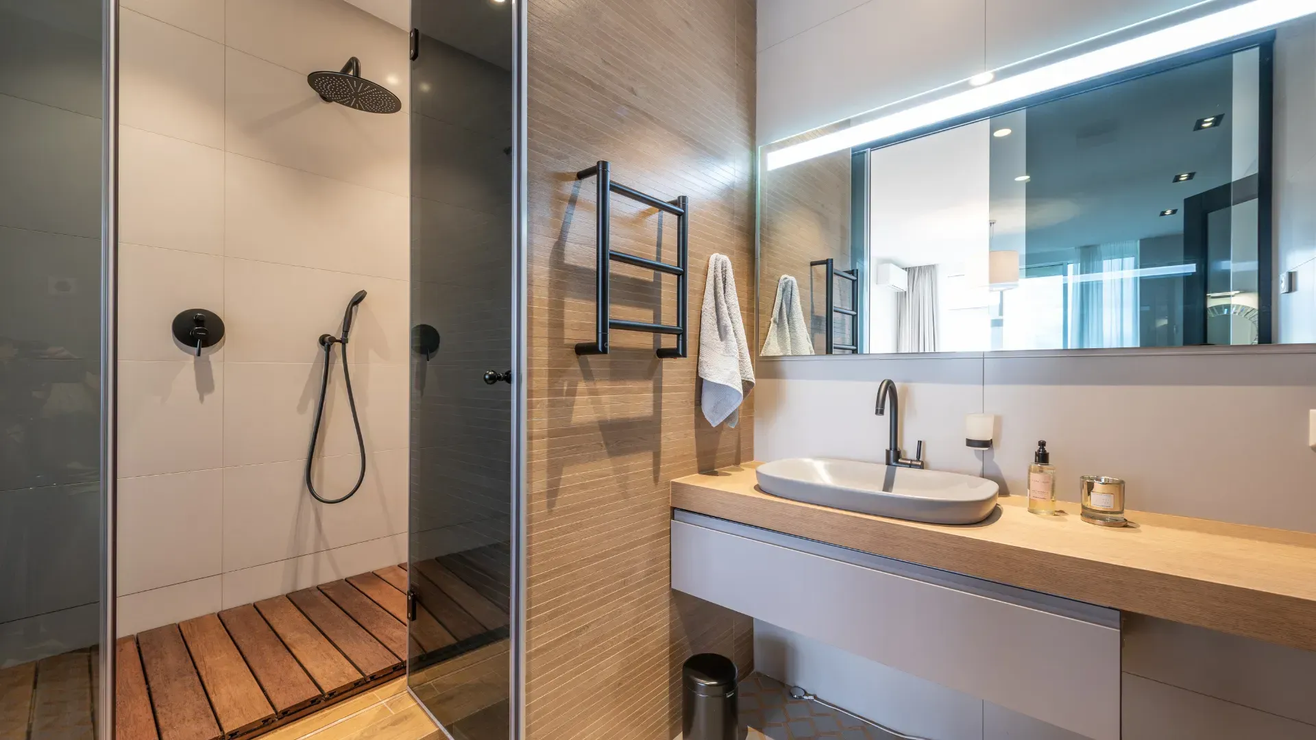 A bathroom with a sink , shower and mirror.
