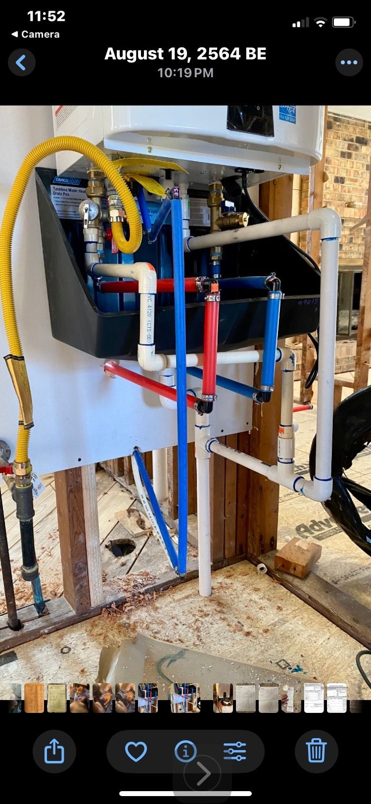 Plumbing installation, including a water heater, with red, blue, yellow, and white pipes.