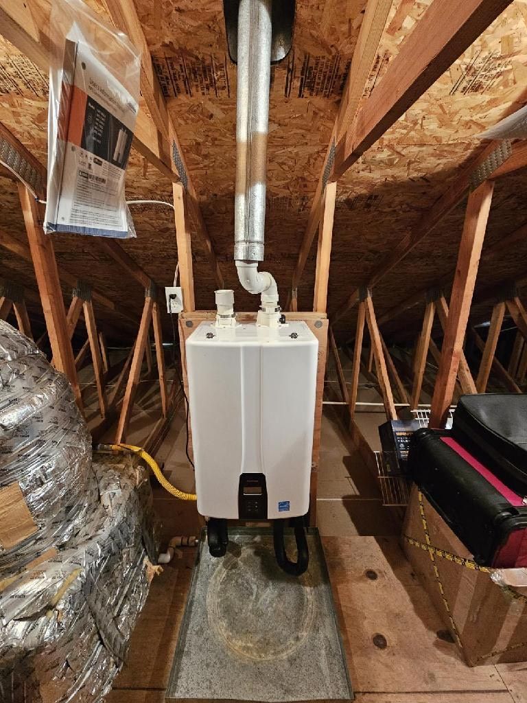 A water heater is installed in the attic of a house, Purist Plumbing and Excavation LLC