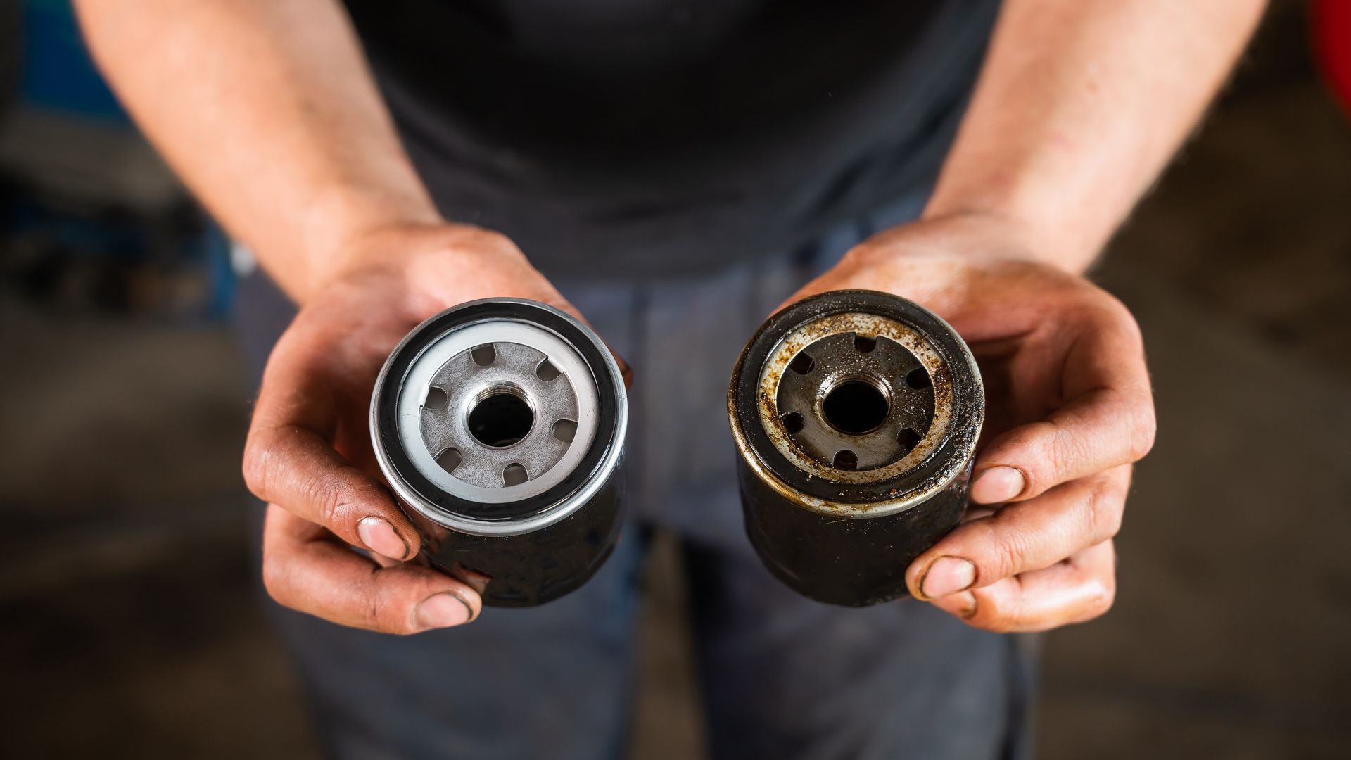 A person is holding two oil filters in their hands | Rozema's Car Care