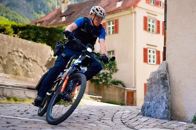 Bike Polizist in Chur fährt in der Altstadt zu einem Notfall