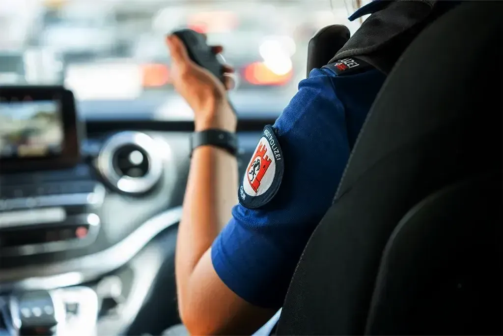 Polizistin der Stadtpolizei Chur mit Funkgerät in Patrouillenfahrzeug
