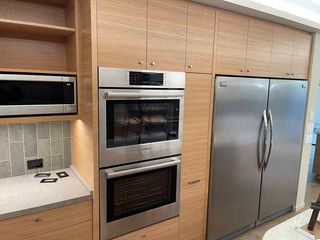 A kitchen with stainless steel appliances and wooden cabinets.