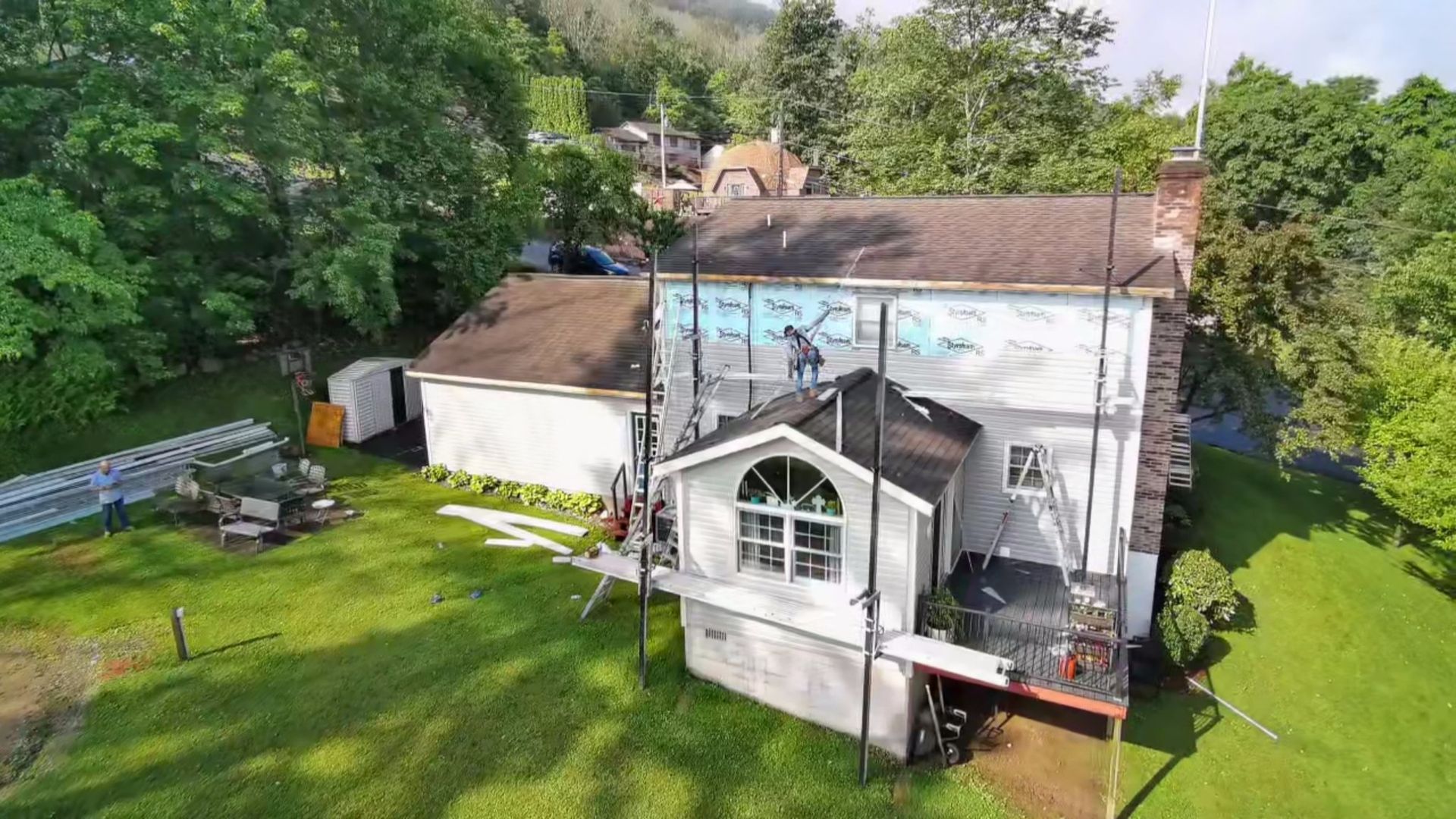 A room floor featuring white, square-tiled vinyl flooring meeting a section of polished wood floor planks.