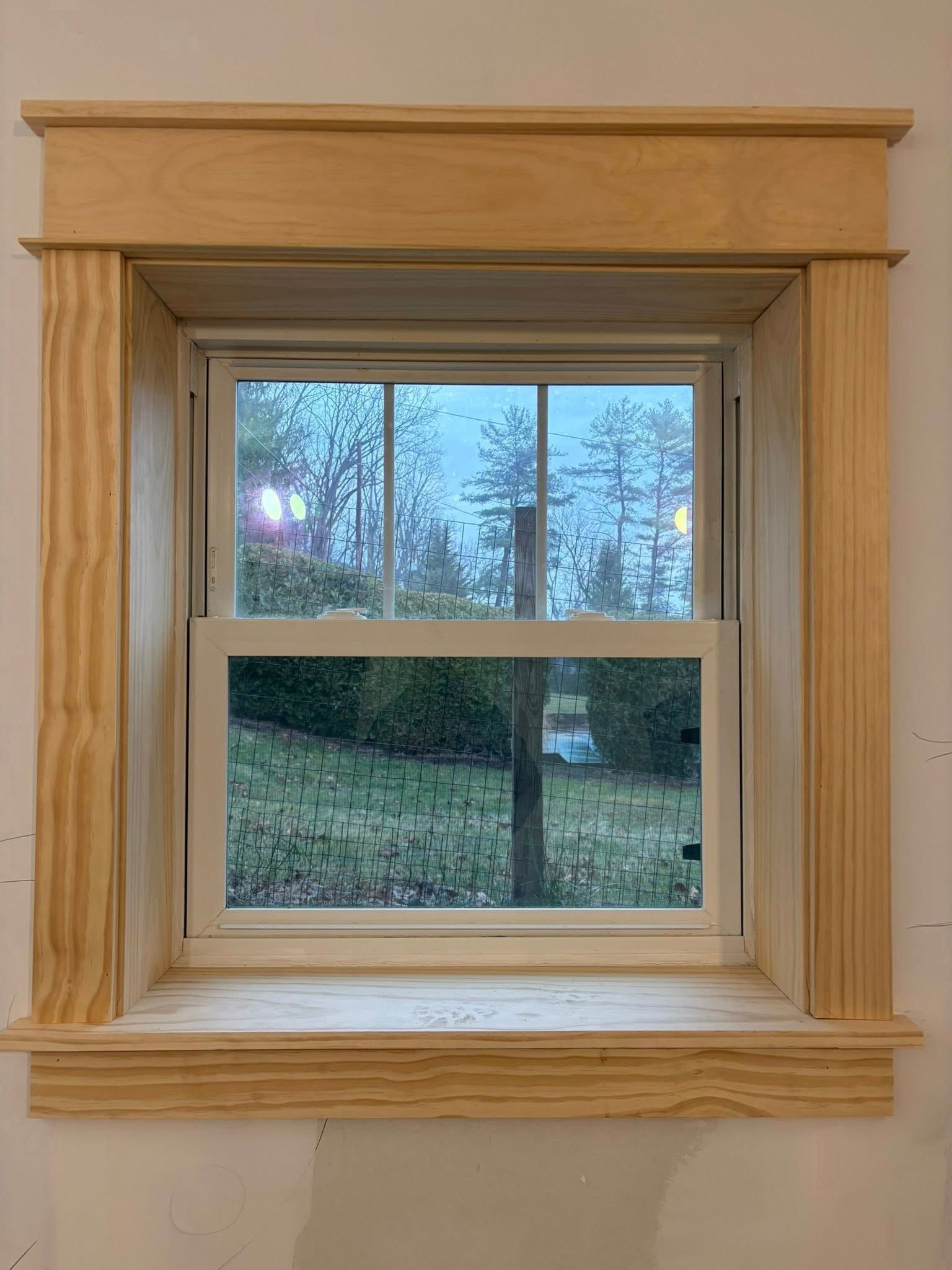 Custom wood cabinetry featuring flat panel and vertical slat doors, set against white shiplap walls with a floor vent.