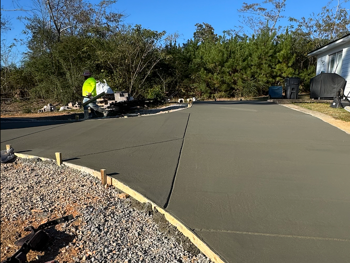 Newly poured concrete driveway with a worker using equipment.