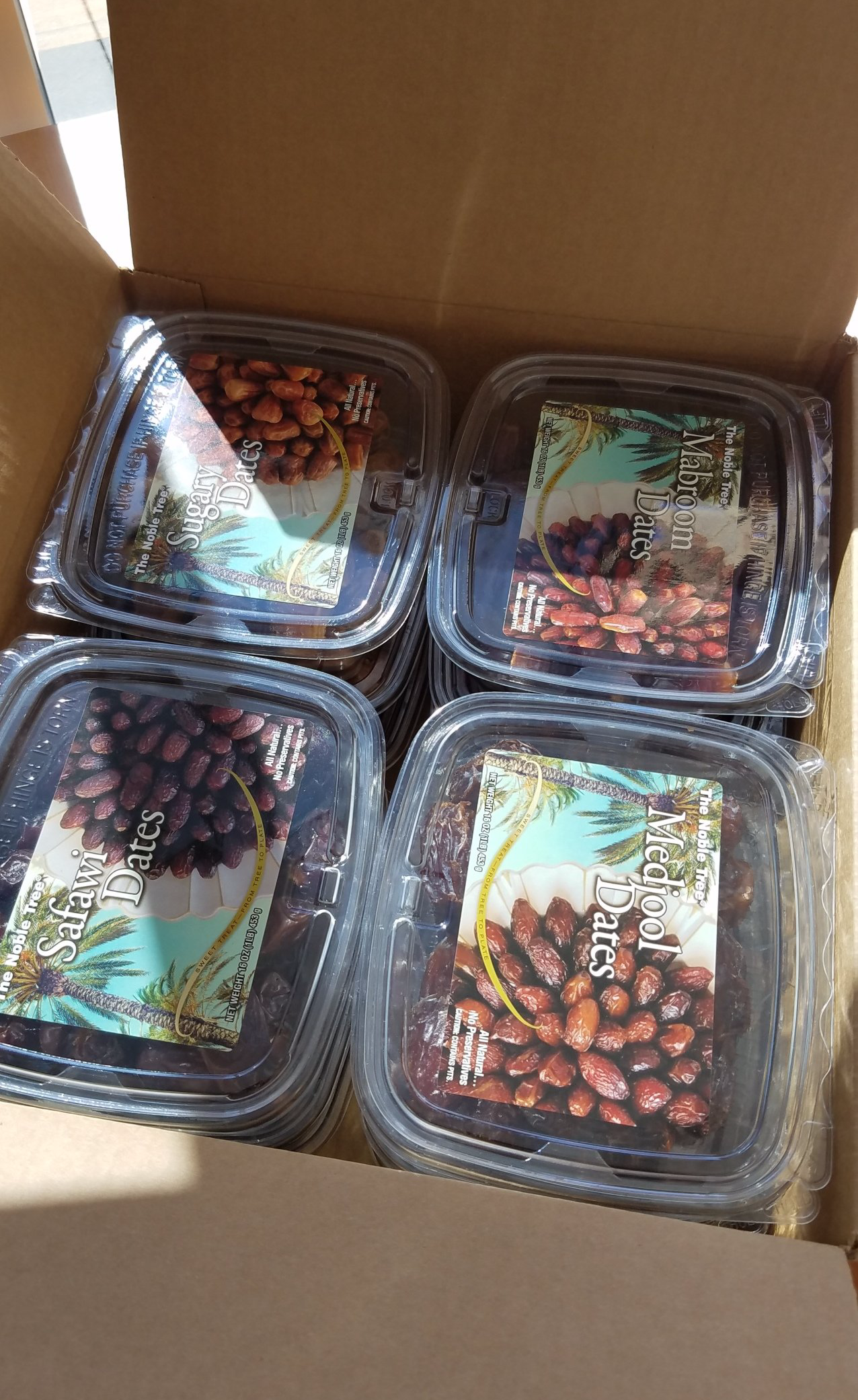 A box filled with four plastic containers filled with different types of food.