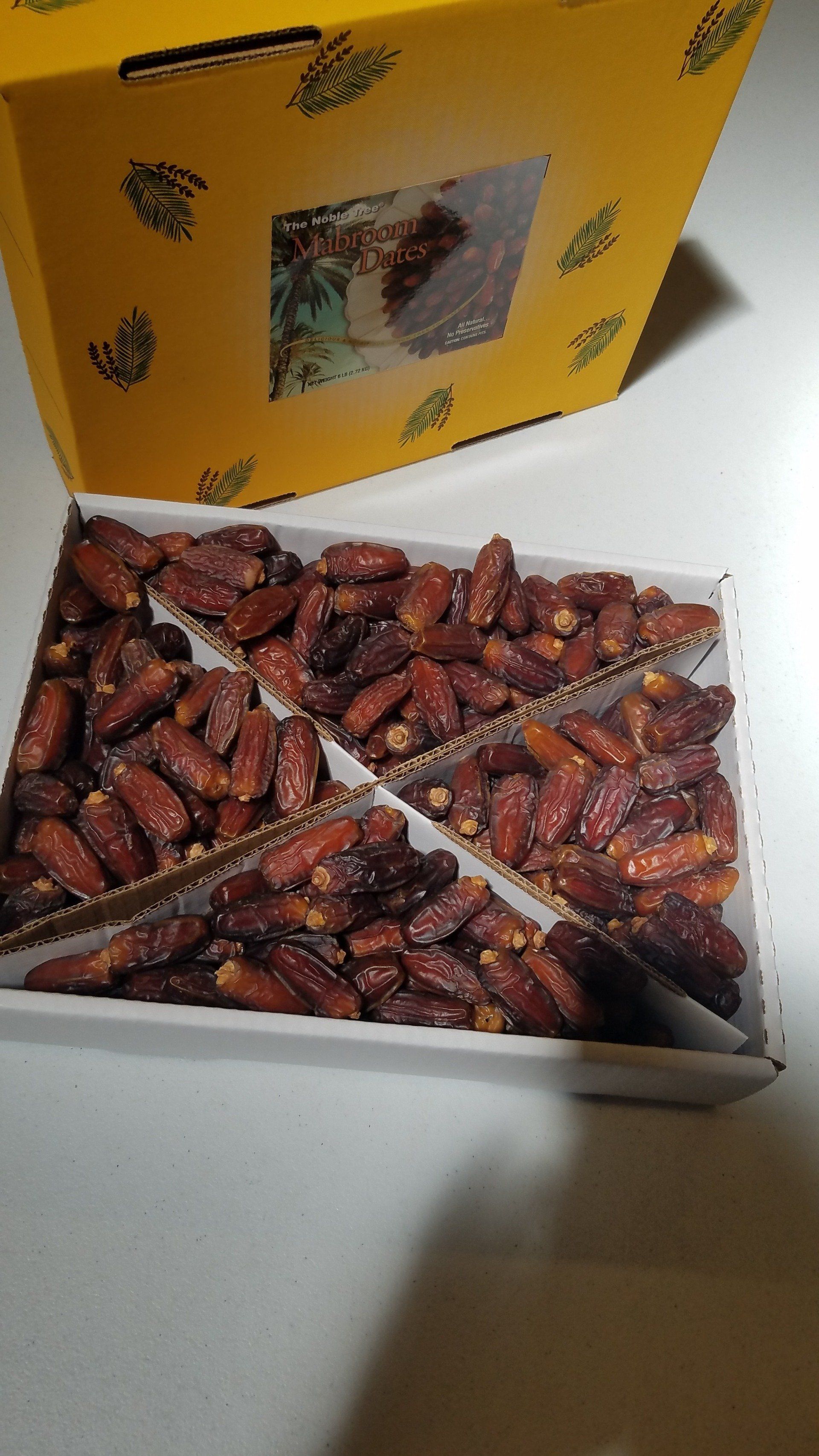A box of dates is sitting on a table next to a yellow box.