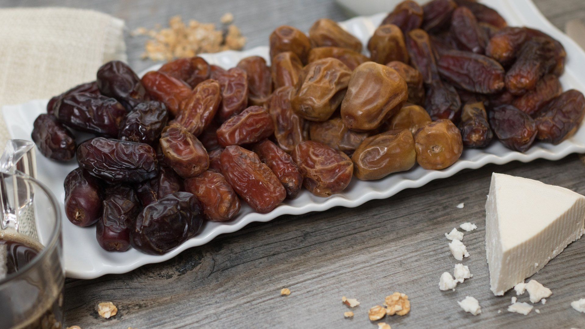 A white plate topped with dates and cheese on a wooden table.