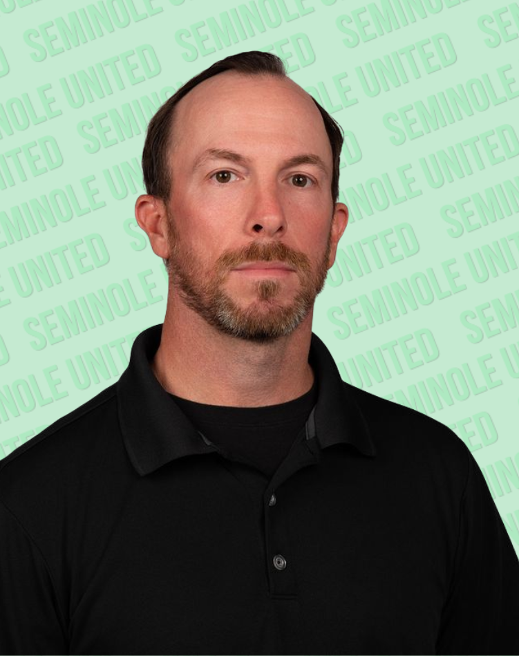 A headshot of someone called Stephen Harrison. He is standing against a purple wall