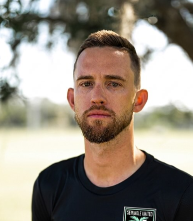A headshot of someone called Petrut Bambanac. He is standing against a purple wall