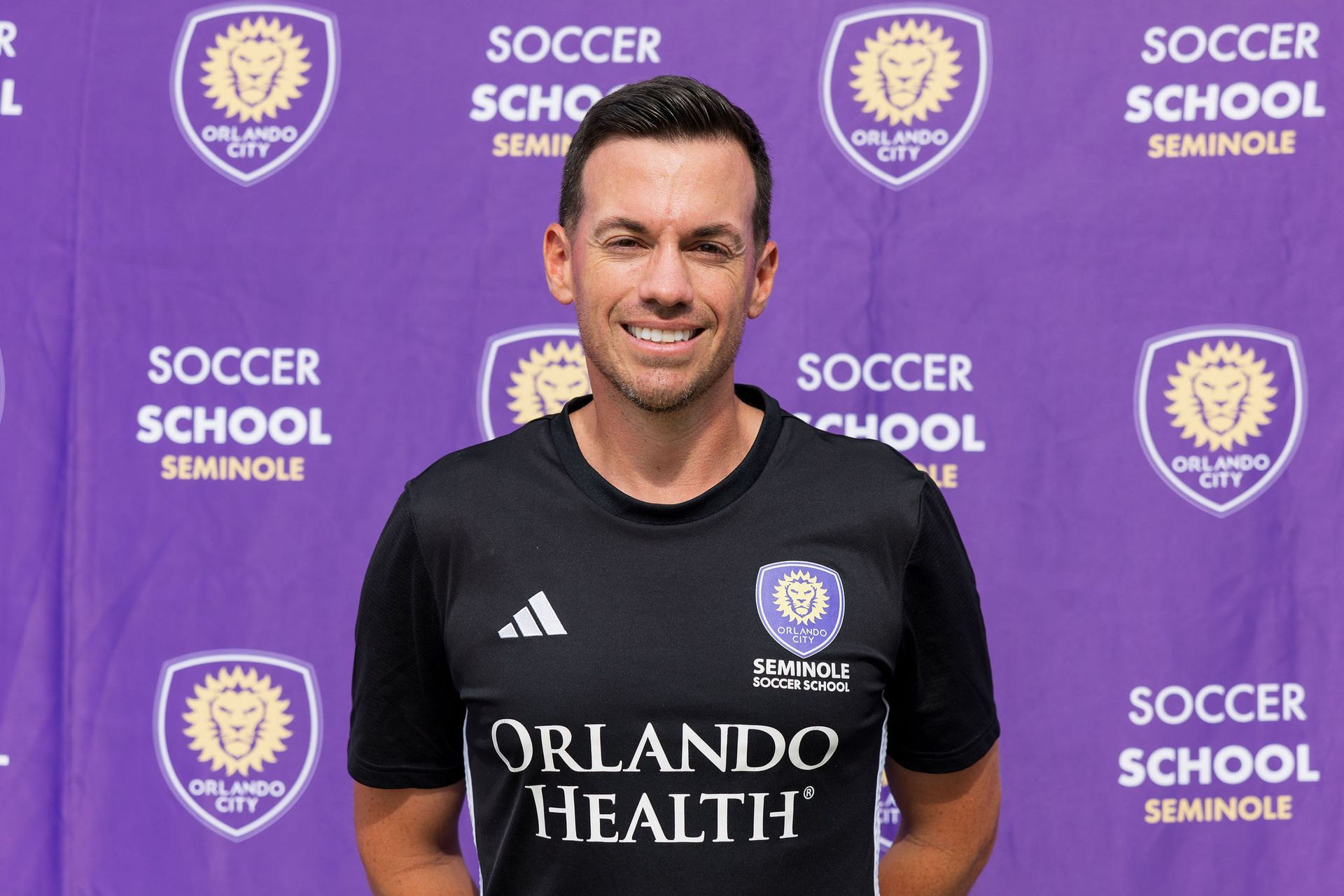 A headshot of someone called Robbie Gobble. He is standing against a purple wall