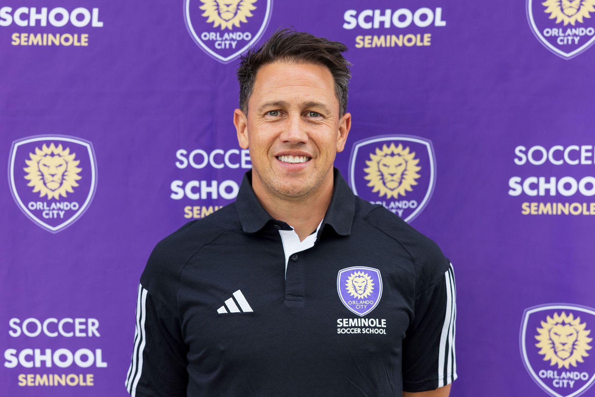 A headshot of someone called Robbie Gobble. He is standing against a purple wall