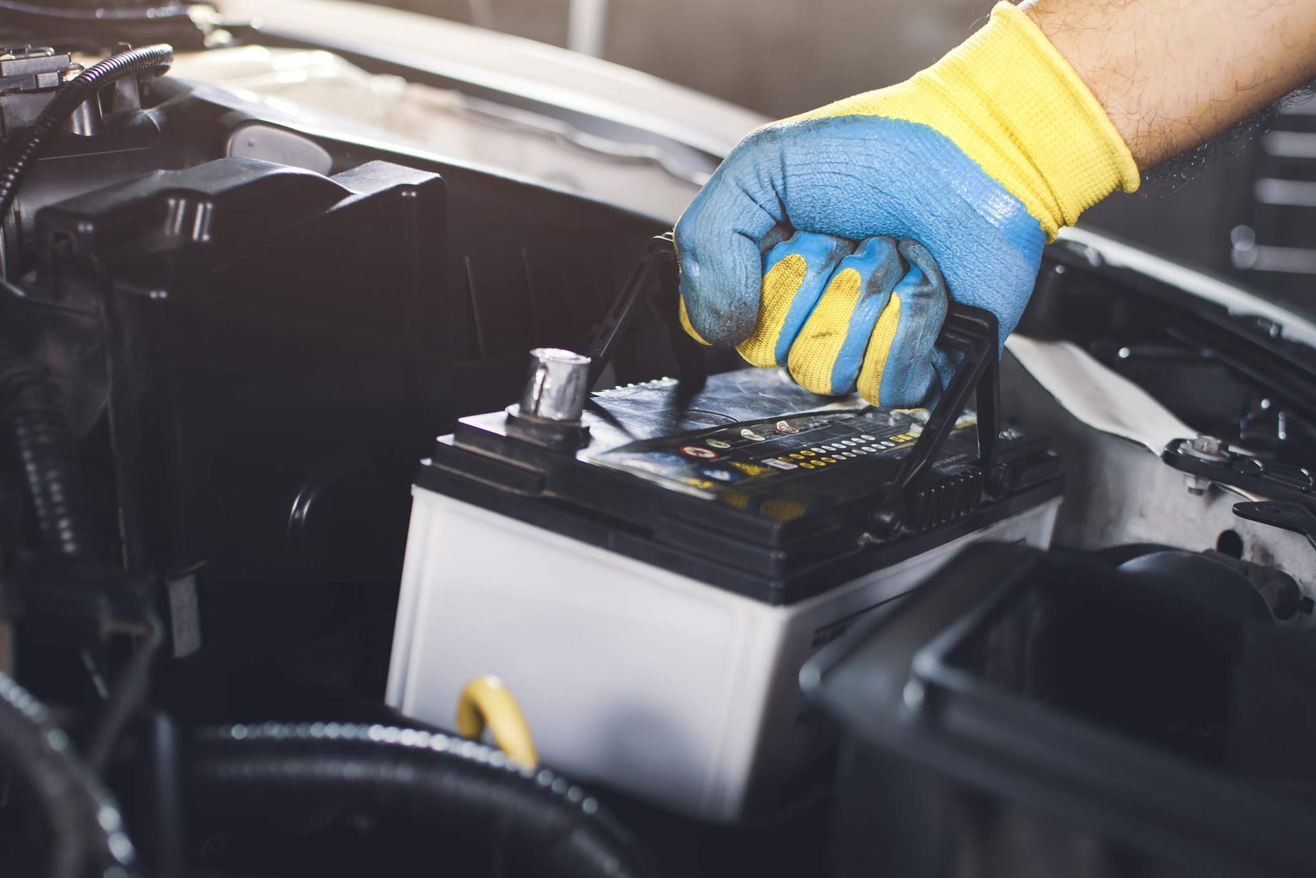 A person is holding a car battery in their hand.