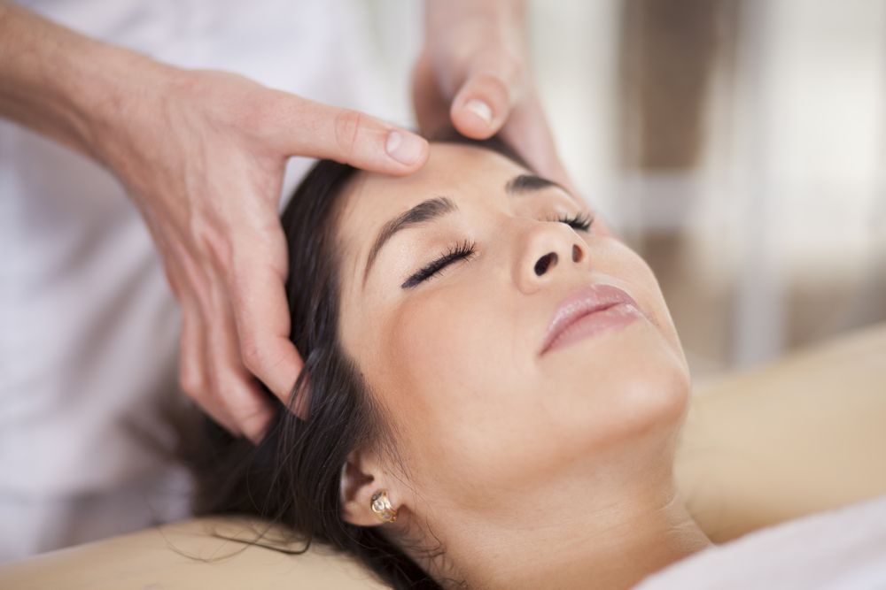 A Woman Is Getting A Head Massage At A Spa — Hands on Healing Massage In Tamworth, NSW