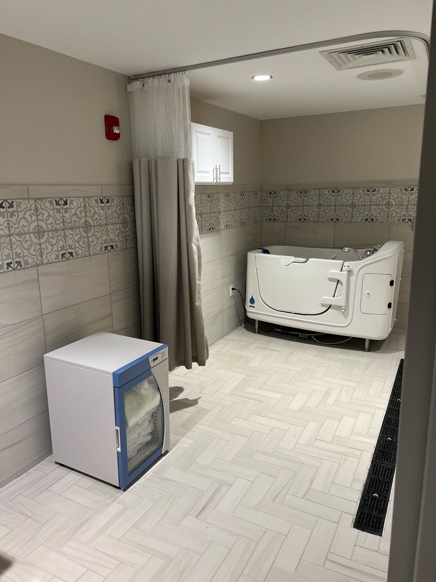 A wheelchair accessible bathing room with a walk-in tub and medical cabinet.