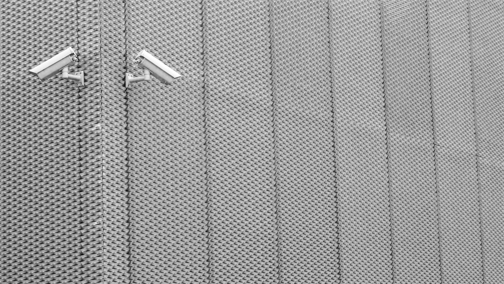 Two security cameras are mounted on the side of a building.