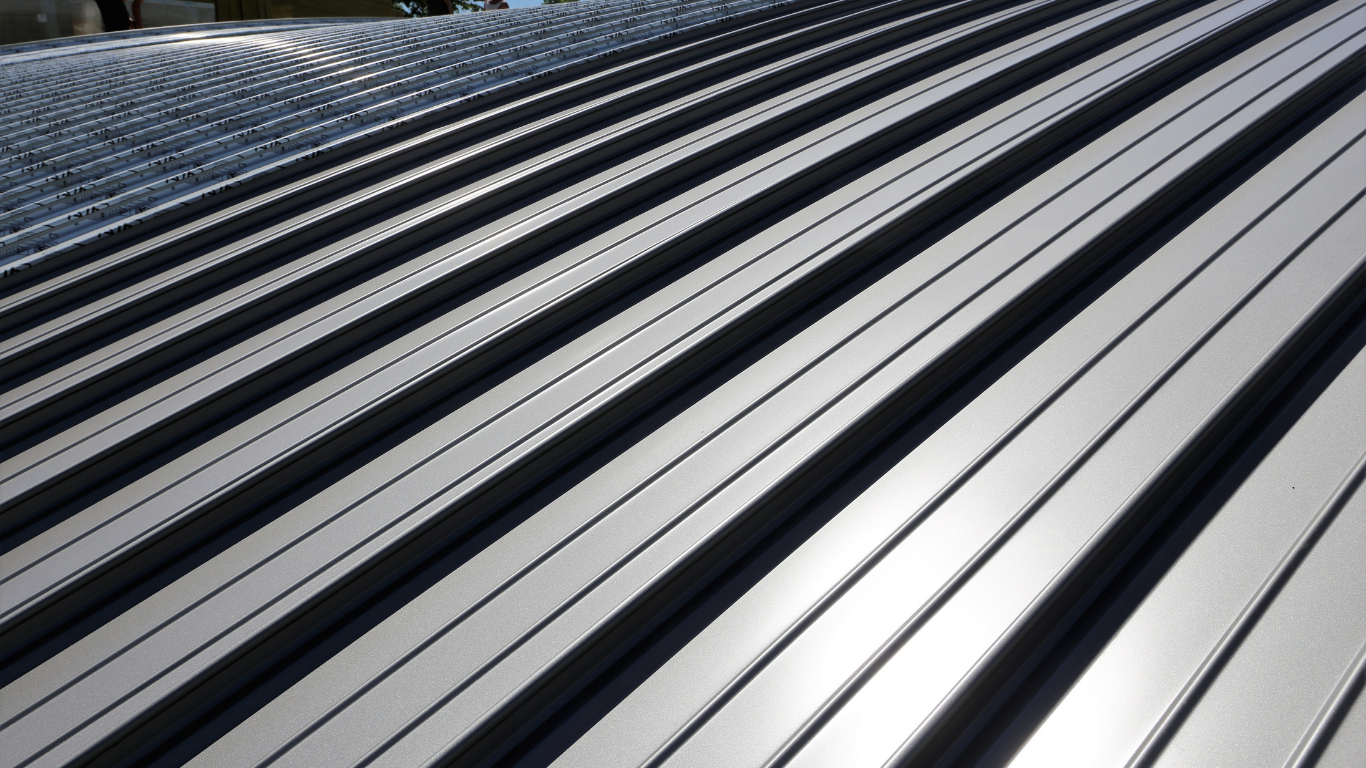 Shiny metal roof with parallel ridges and dark shadows.