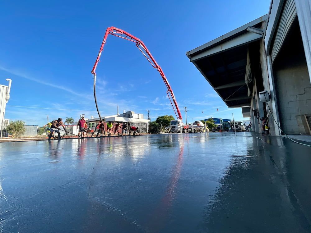 Construction Workers Pouring Concrete on a Large, Wet Surface — LS Plant Hire in Calliope, QLD