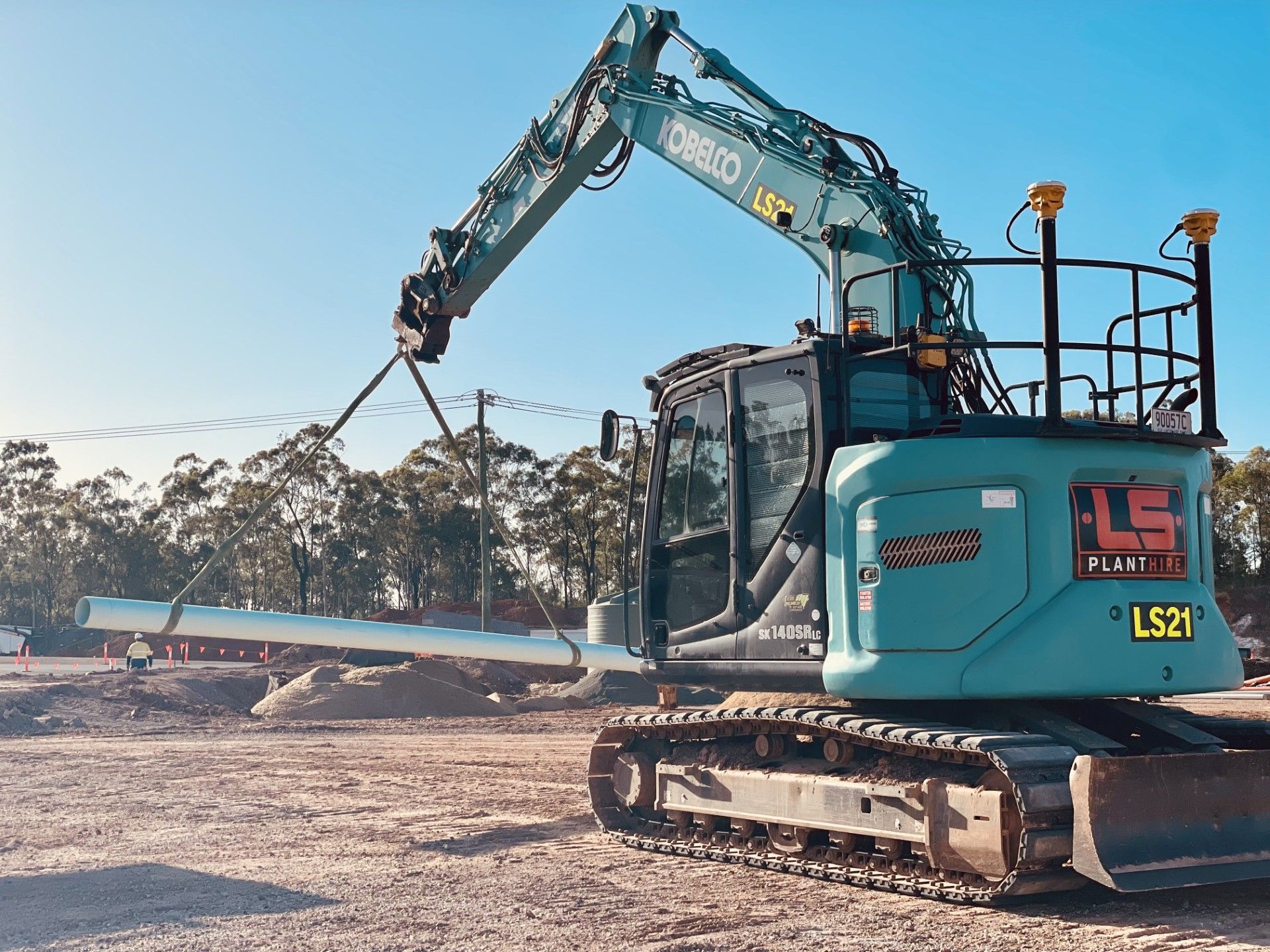A teal Kobelco excavator with the label 