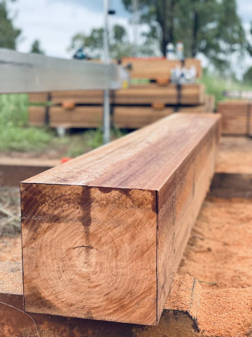 Square-cut, Reddish-brown Timber Beam, Sawn at a Sawmill, Resting on Supports — LS Plant Hire in Calliope, QLD