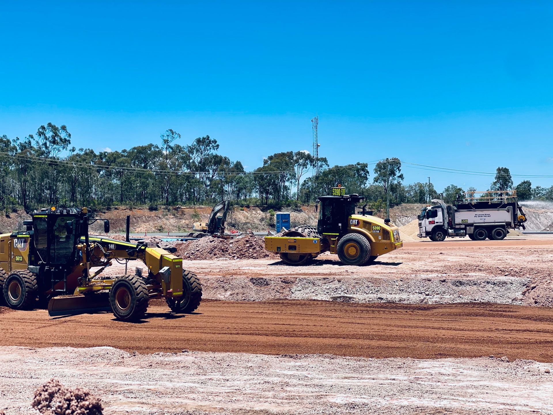Construction equipment, including a yellow motor grader, a soil compactor, and a dump truck, working on a dirt site. — LS Plant Hire in Calliope, QLD