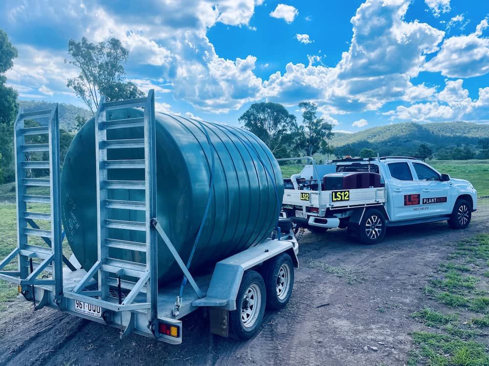 Green Water Tank on a Trailer Being Towed by a White Truck in a Rural Setting — LS Plant Hire in Calliope, QLD