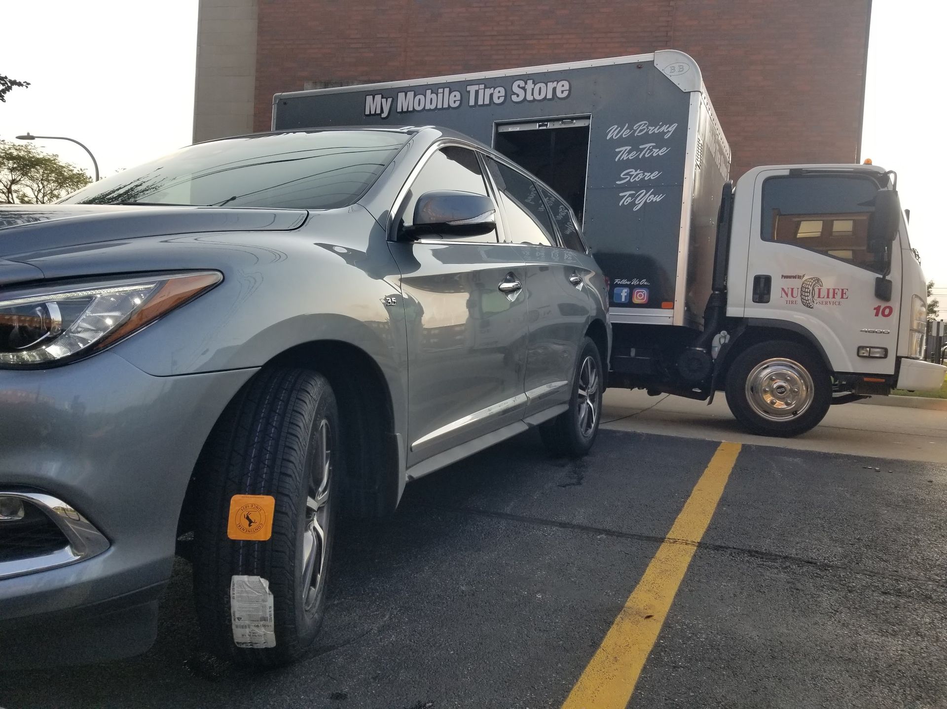 A person is changing a tire on a car with a wrench.