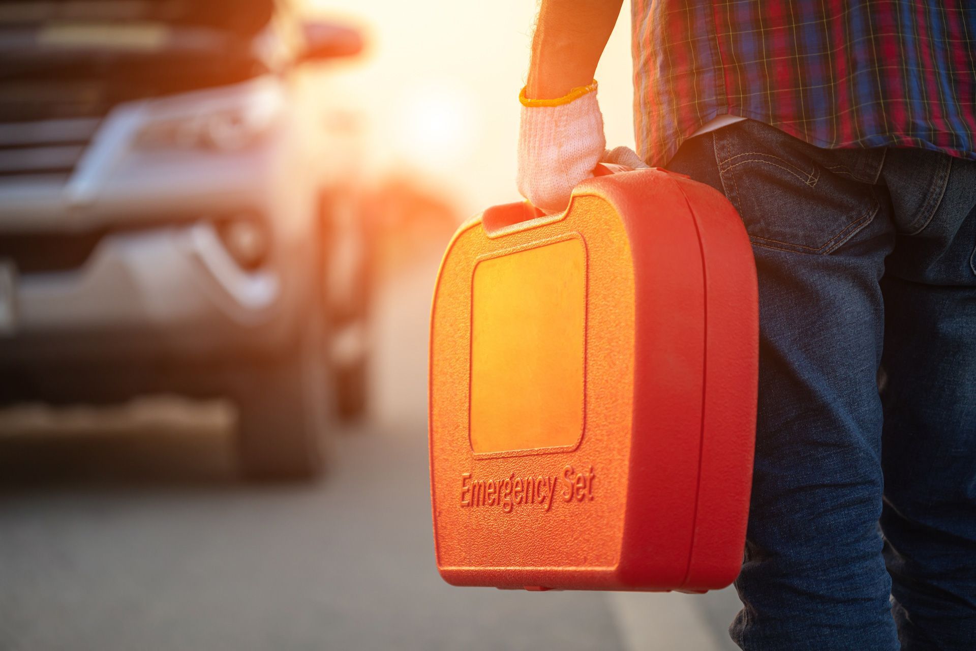 A man is holding a gas can on the side of the road.