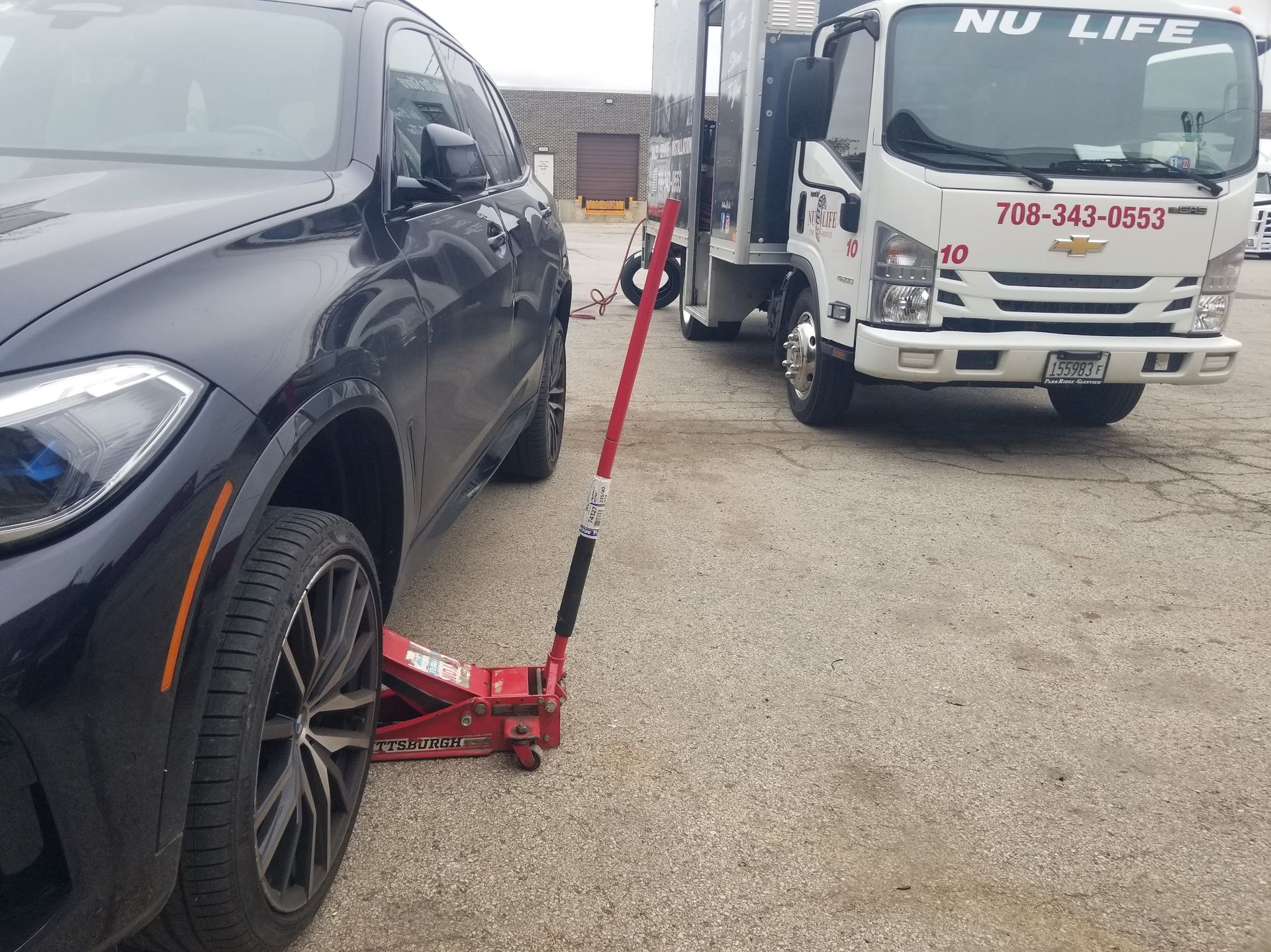 A car with a flat tire is parked on the side of the road.